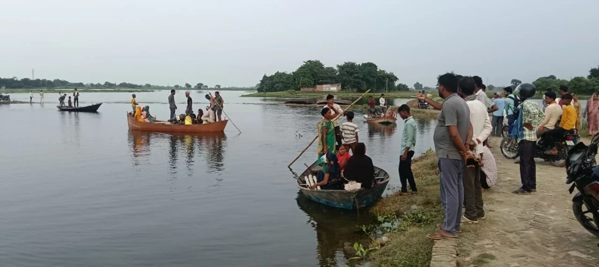 Photo: Life at stake in flood at Belhiya Dhala: Minors hold the rudder of the boat, administration silent